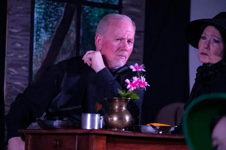 Two actors sharing a serious moment during a stage performance