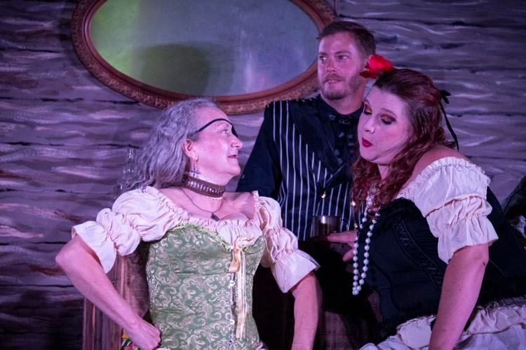 Three actors in period costumes performing together on the Diversity Theater stage