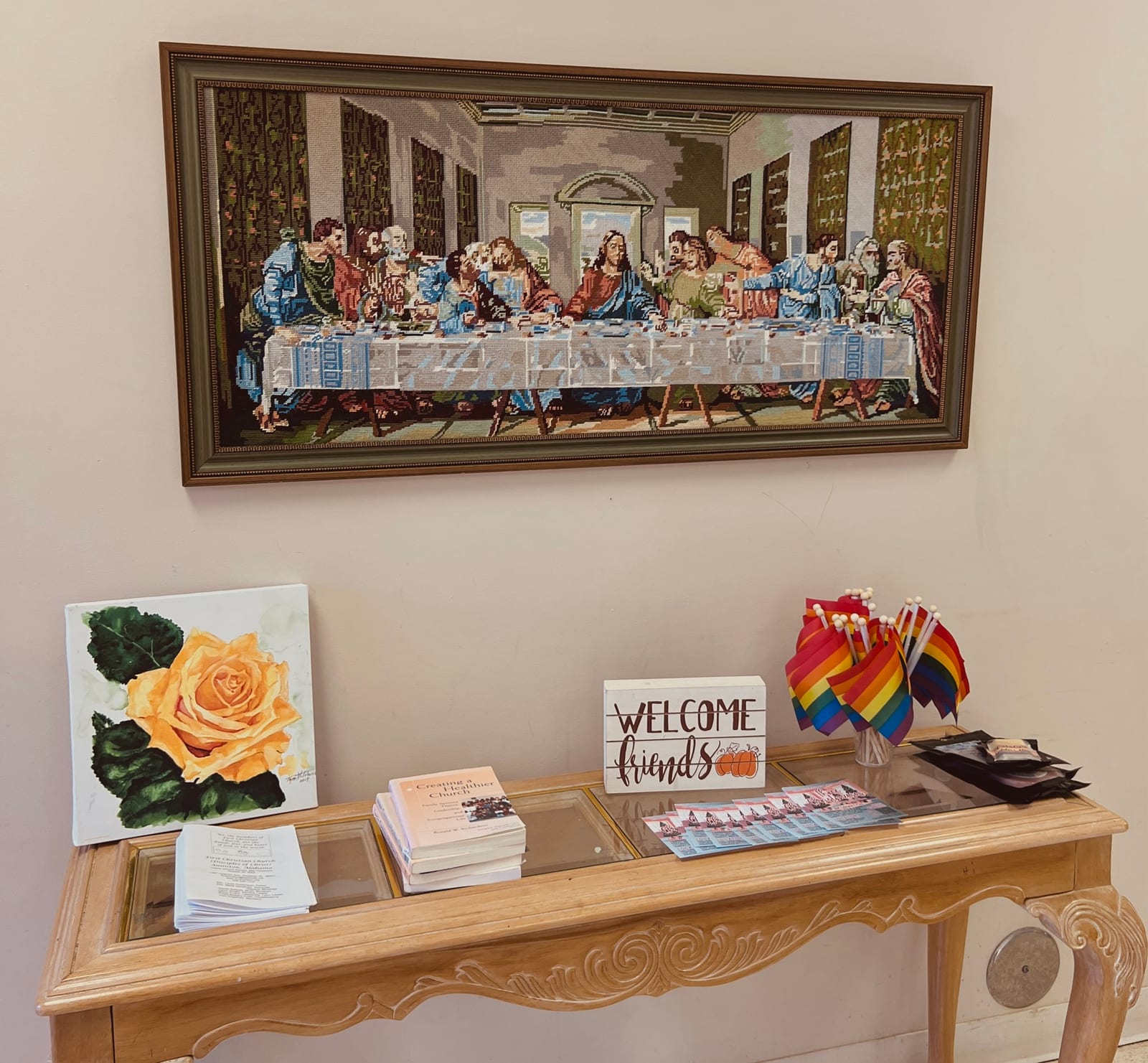 The church welcome area with visitor materials, artwork, and rainbow flags